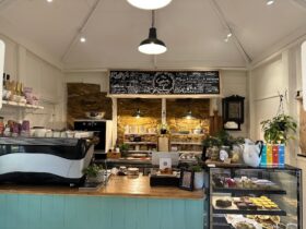 Cafe counter with exposed original stone walls at the back. Coffee, cakes, pastries and teas