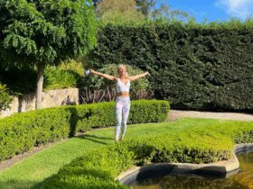 Nikki welcoming the sun in nature around lush green surroundings
