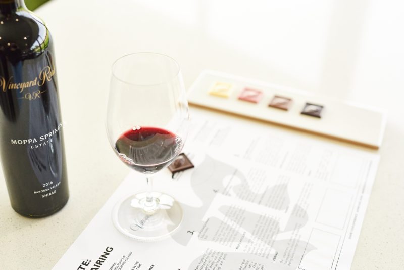 chocolate tiles on wine tasting sheet with wine glass and bottle