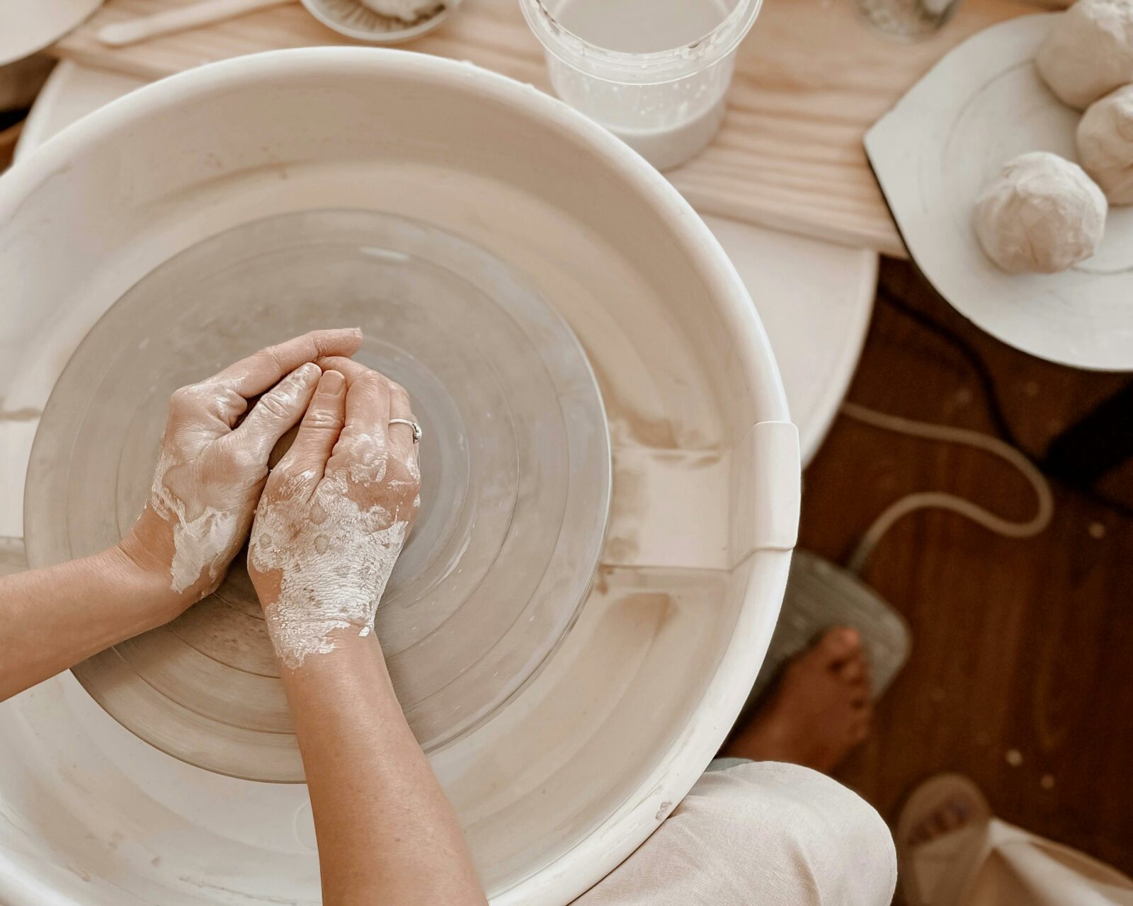 Hands mould clay on pottery wheel
