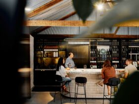 3 guests at the tasting bar at Krondorf Cellar Door wit h modern stone & rustic wood features