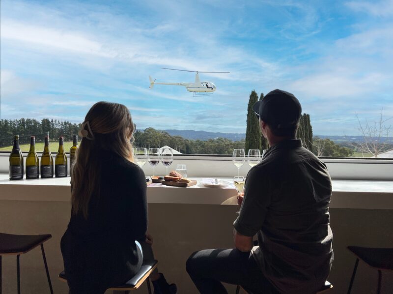Guest's enjoying their tasting flight at The Lane, watching South Australian Helicopters arrive.