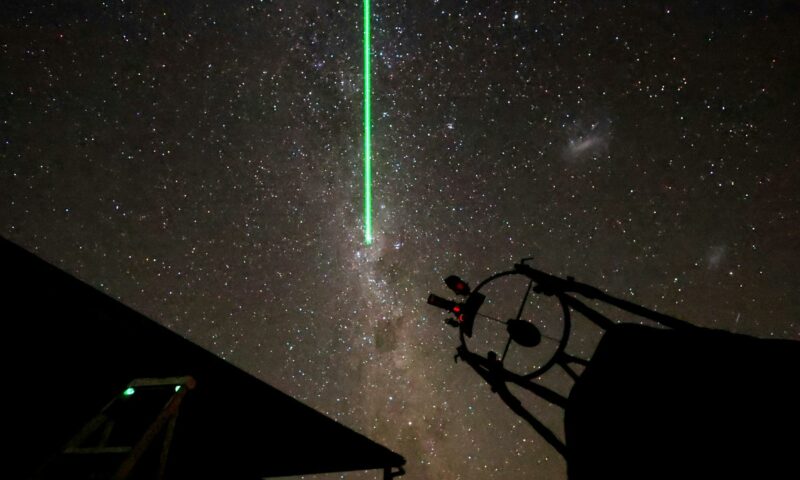 Laser pointer showing Milky Way over telescope