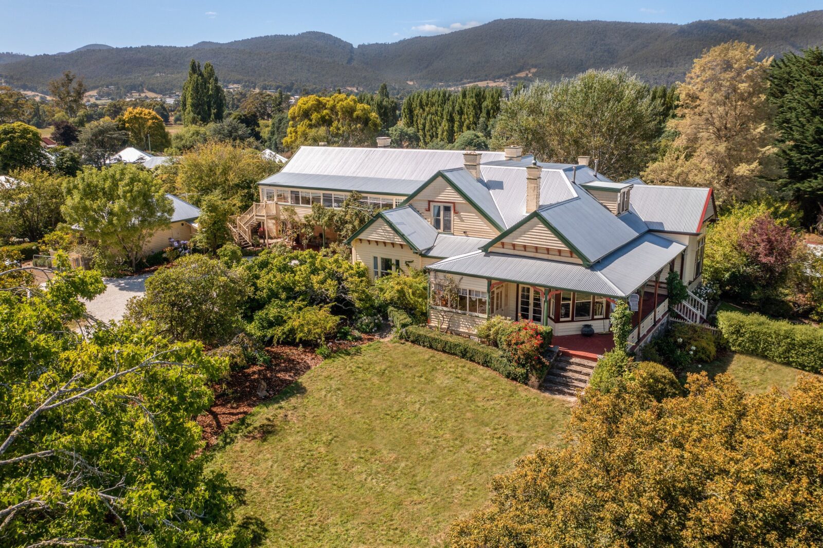 A large, historic weatherboard home within landscaped grounds. The building looks well maintained.