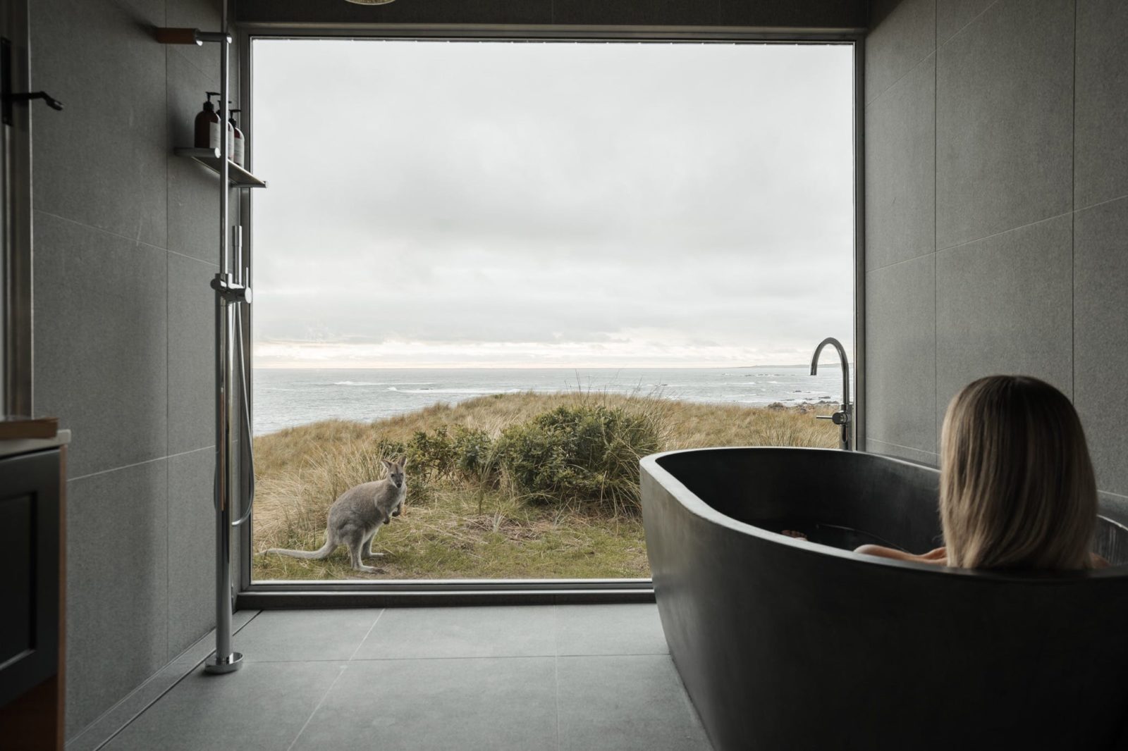 Hand made concrete bath tub with panoramic views through a wall of glass, relax surrounded by nature