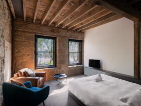 Bricked-over escape passage, sandstone walls, exposed beams, armchairs, king size bed, TV