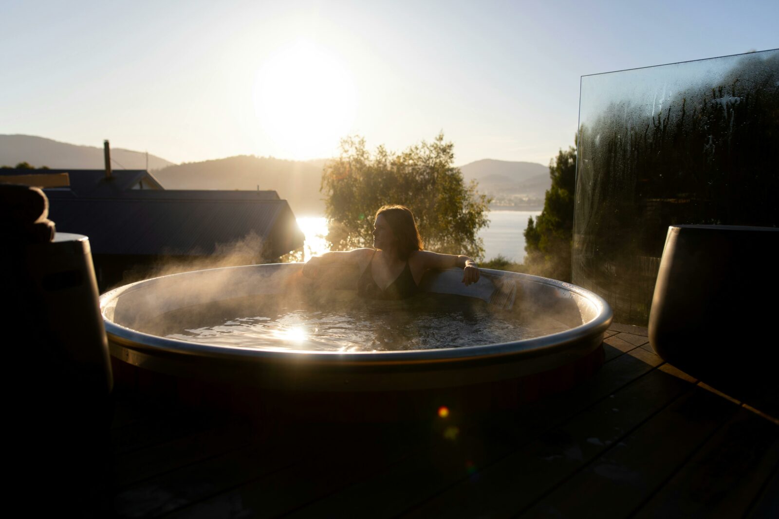 Photo of a person in a hot tub with a view over the bay