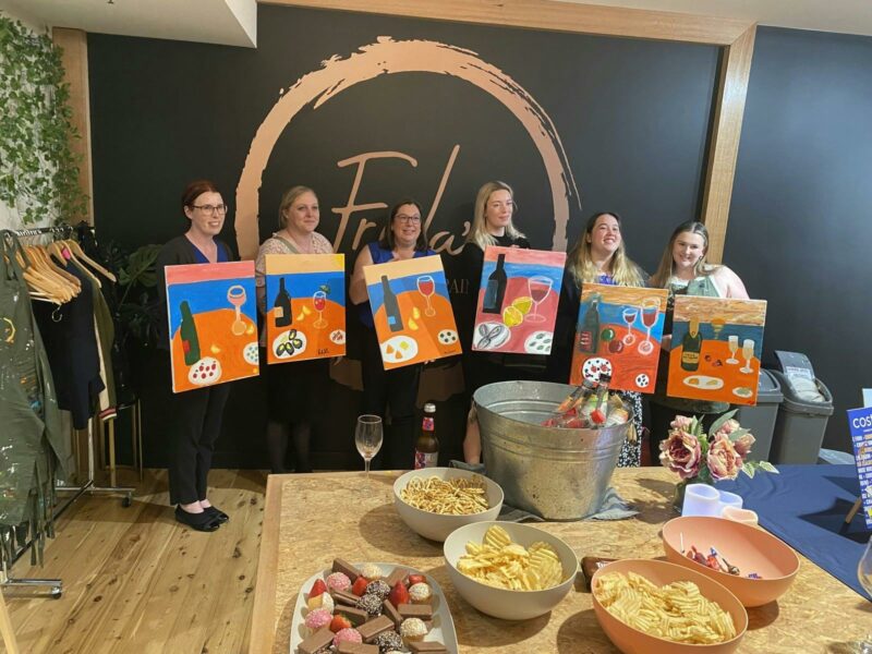People showing off heir finished paintings