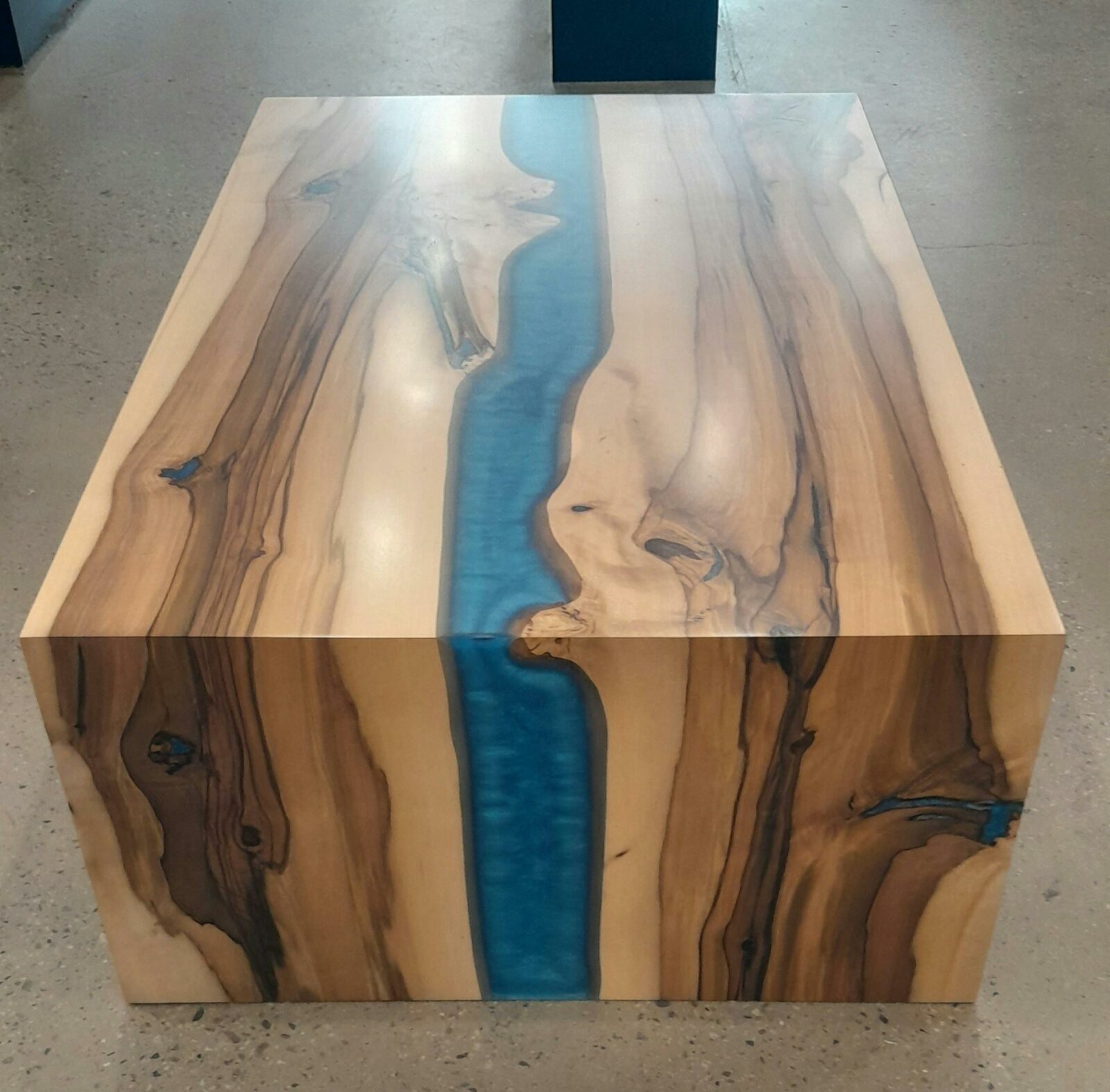 Picture of a coffee table with dark and light stripes and a blue river in the middle