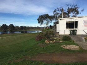 A shot of the club house and practise green with the lagoon in the distance