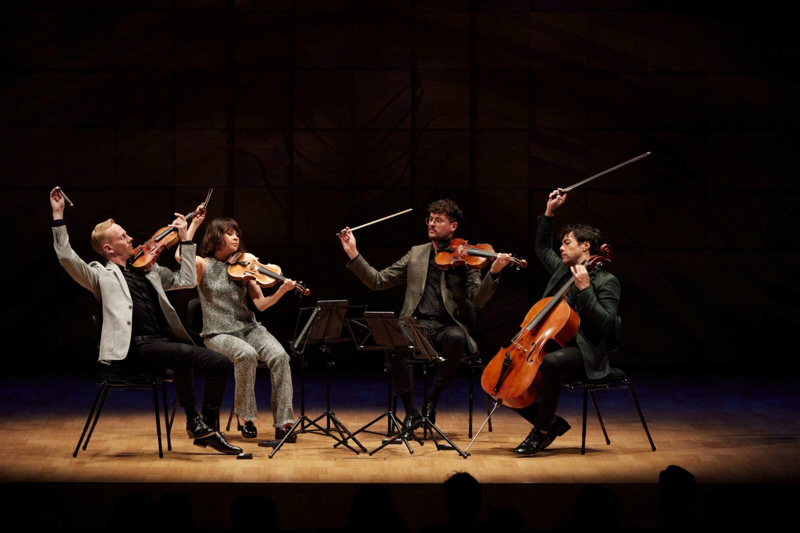 A string quartet in a spotlight on a drkened stage