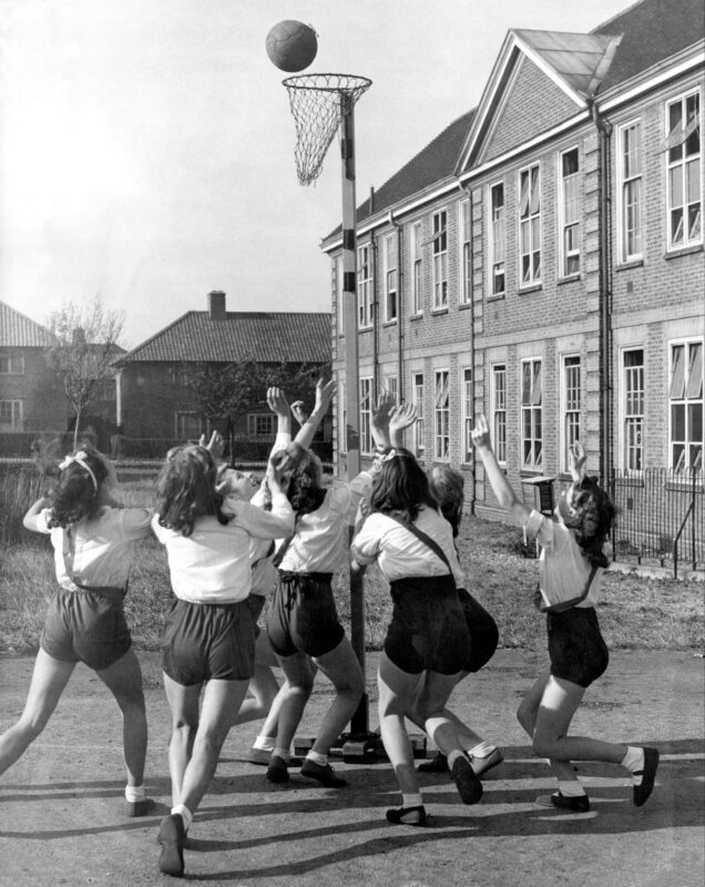 A circa 1950s photo of a group of girls looking upwards while playing netball