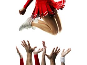 cheerleader in the air with bent legs with hands reaching up to catch them