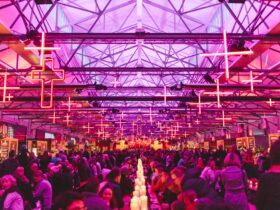 Under neon crosses and candlelight, diners fill the long banquet hall of the Dark Mofo Winter Feast
