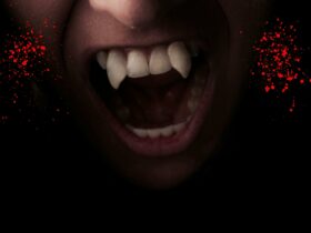 Open mouth with vampire fangs and blood splatter