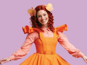 Red haired woman with orange tutu smiling at camera