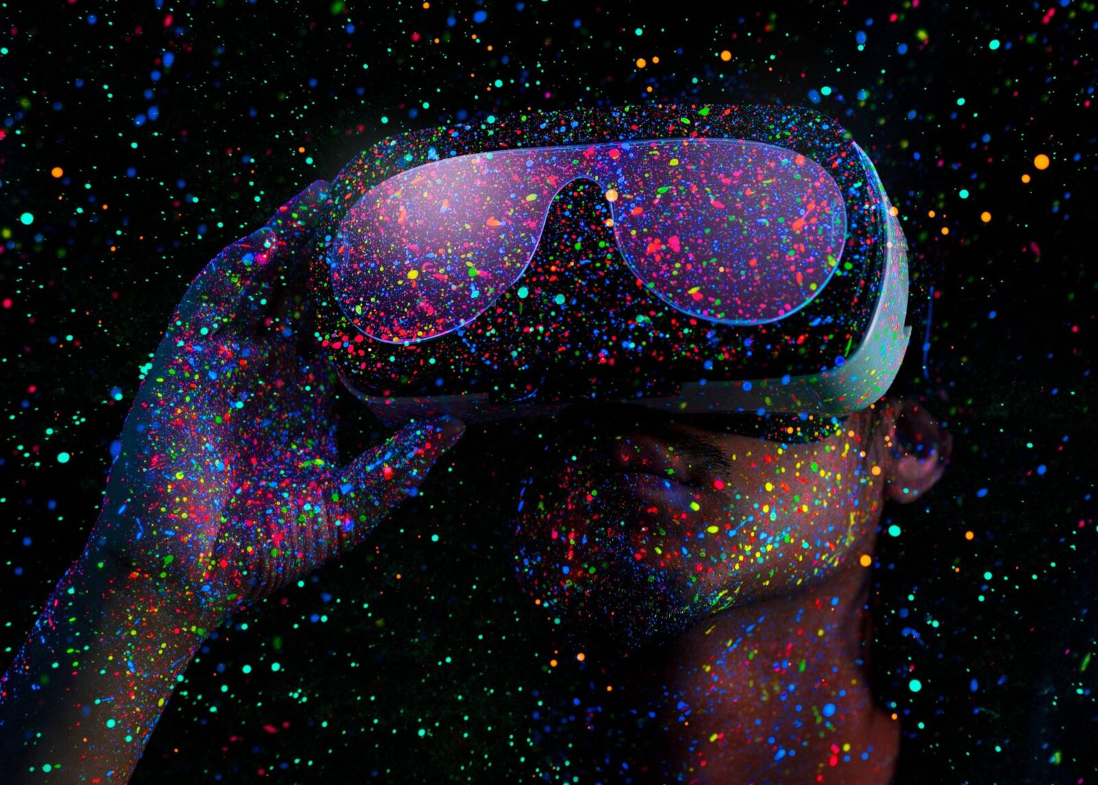Photo of a person wearing a VR headset. Dots of coloured light are speckled across the image.