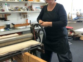 Deborah Wace using one of her etching presses during a Print, Press & Draw workshop.