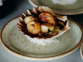 Exquisite seared scallop canapé nestled in its shell, ready to delight at our Winter dining event