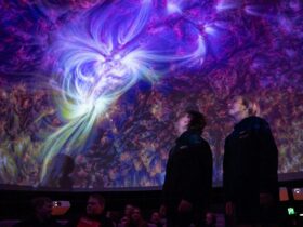 Two people standing in the planetarium during a presentation.