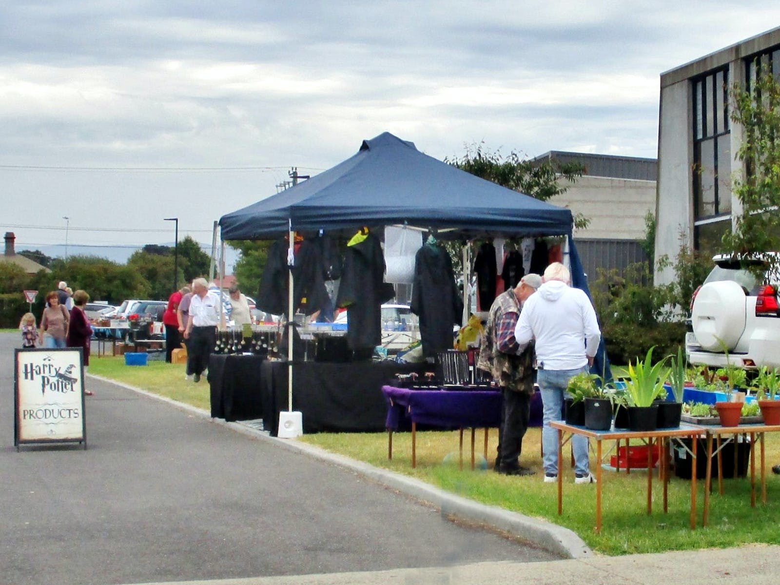 A marquee stall, green grass and flowers. The windows of the Graham Fairless Centre to the left