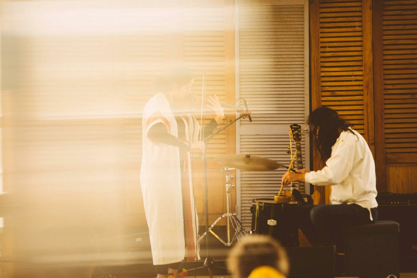 An abstract photos of two musicians with a golden hue