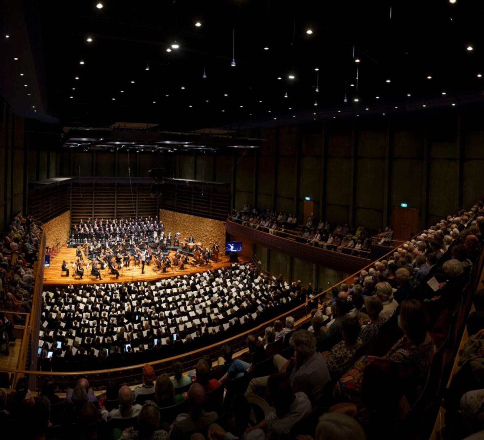 Photo of an orchestra, taken from the balcony of a concert hall.