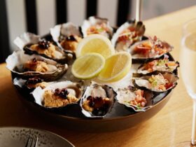 A plate of a dozen Tasmanian Pacific Oysters with sea urchin and smoked salmon topping