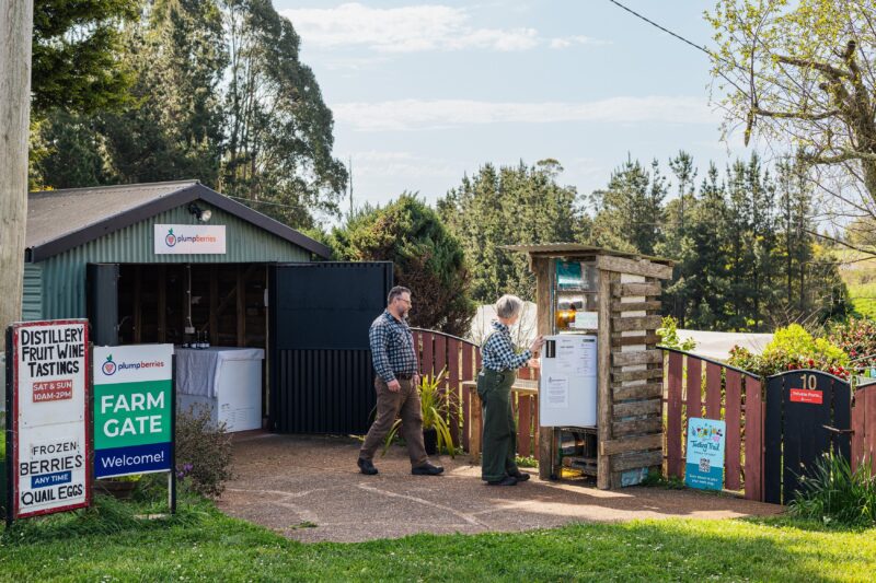 farm gate shed and self-serve station with two people