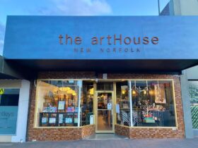 The exterior of the artHouse New Norfolk. Dark green signage with rusty metal letters over windows.