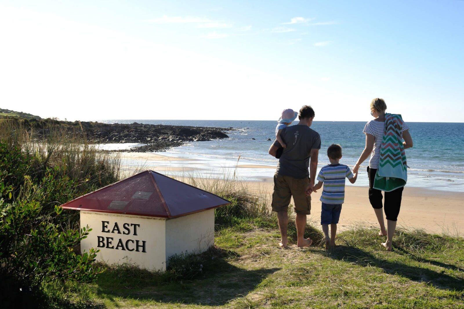 This image shows a family walking towards East Beach.