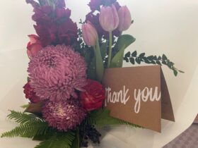 Beautiful purple and pink flowers with a thank you card