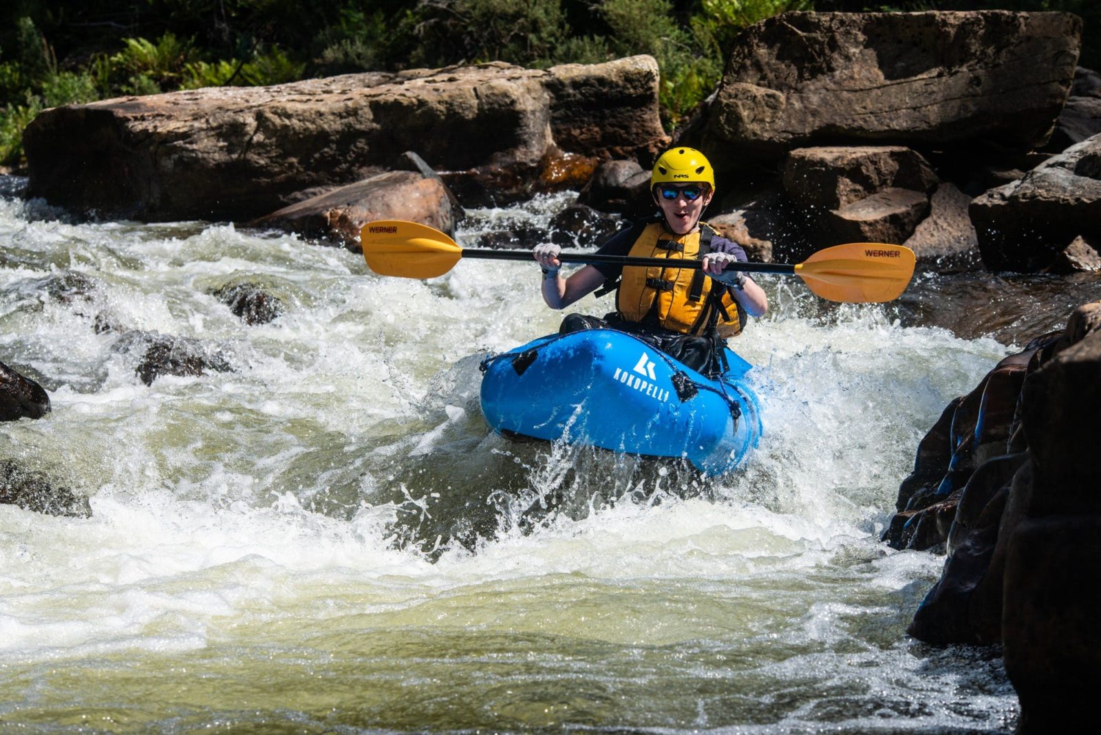 A person paddles a packraft down a rapid in Tasmania.