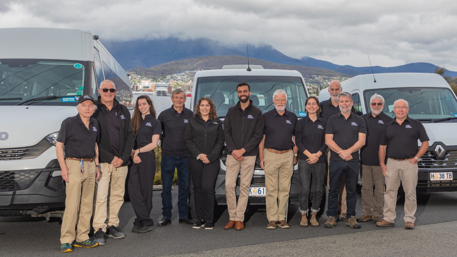 Our professional tour guide team and luxury vehicles in front of Mount Wellington and a cruise ship