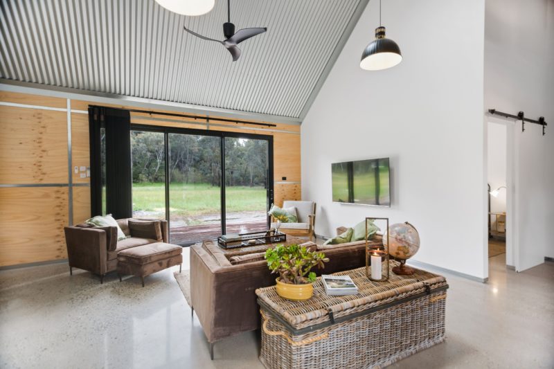 BIG Shed Lounge area with large sliding door , cathedral ceiling and fan
