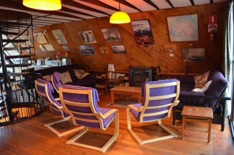 Living Area - with gas fire, sofas and lounge chairs. Images of Antarctica on the walls.