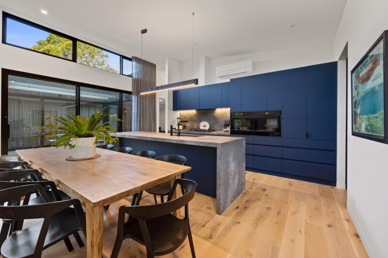 View of large timber kitchen table with seating for 10 and Navy and Slate kitchen with dual ovens