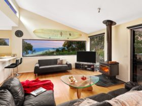 Stunning coastal views from the lounge with fireplace and huge TV