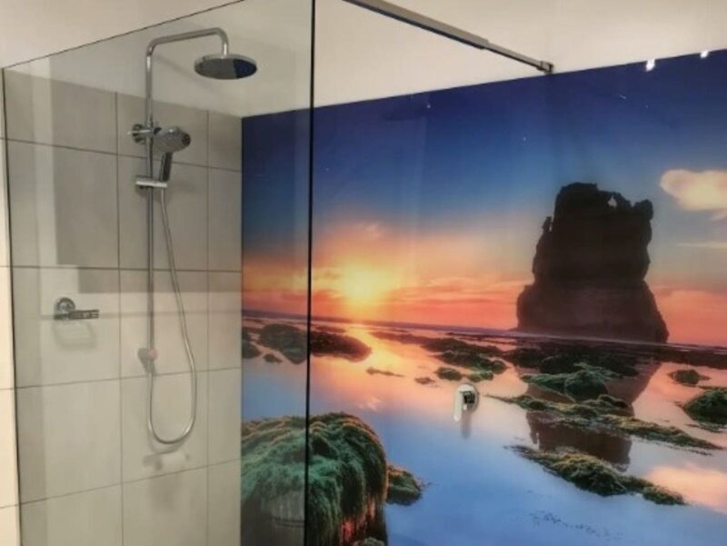 Modern shower with a wall featuring a large print of Gibson Steps at sunset