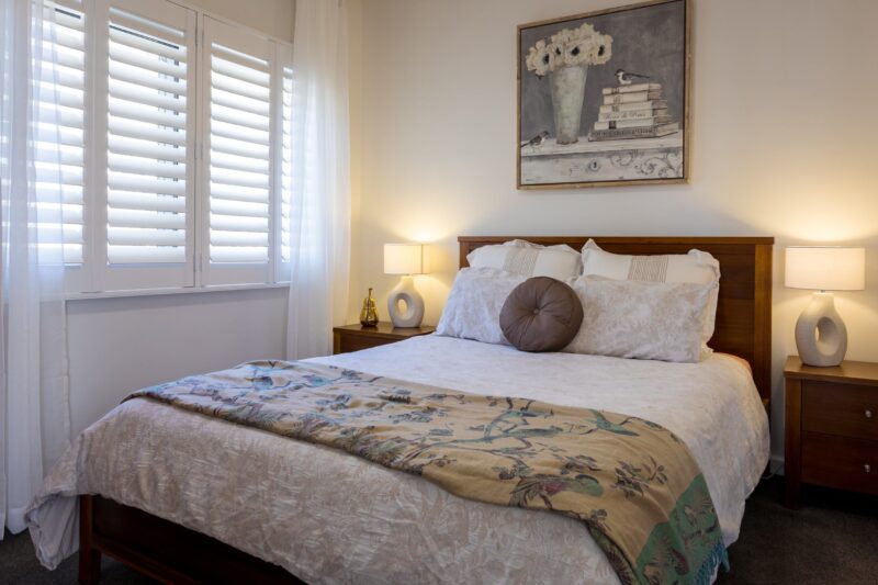 Bedroom, queen size bed, pillows, lamp, plantation shutters