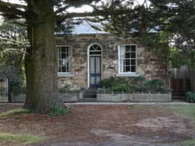 Historic stone cottage nestled under the giant Norfolk pies