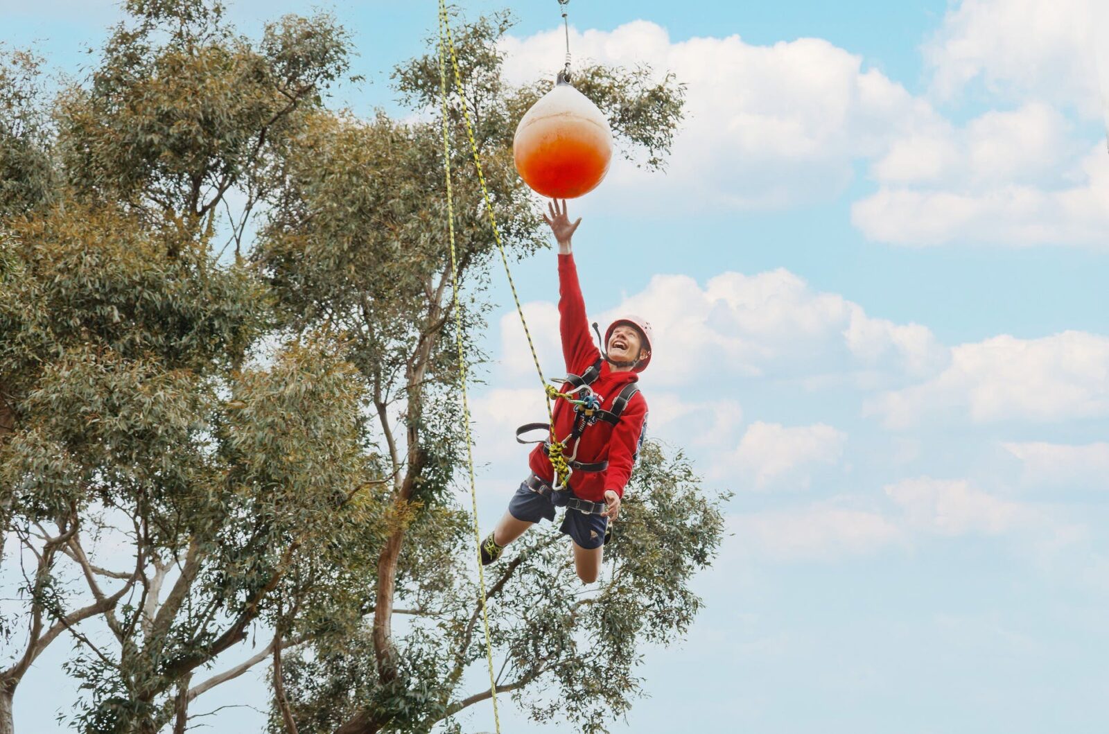 A boy jumping out to touch a target on the leap of faith at PGL Campaspe Downs