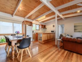 Beach house with open plan kitchen, meals, living. Timber floors and beams. comfortable seats