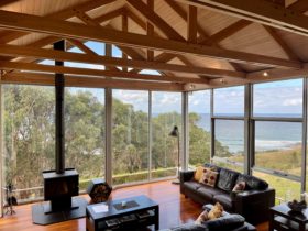 Living-room with large leather sofas, free-standing wood stove with views all around