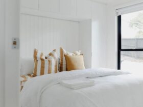 White bright room with king bed and all linen provided, cushions at top of bed. Panel walls