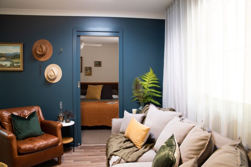 Loungeroom, rich tan leaner armchair, large sofa, decorative wall art, modern
