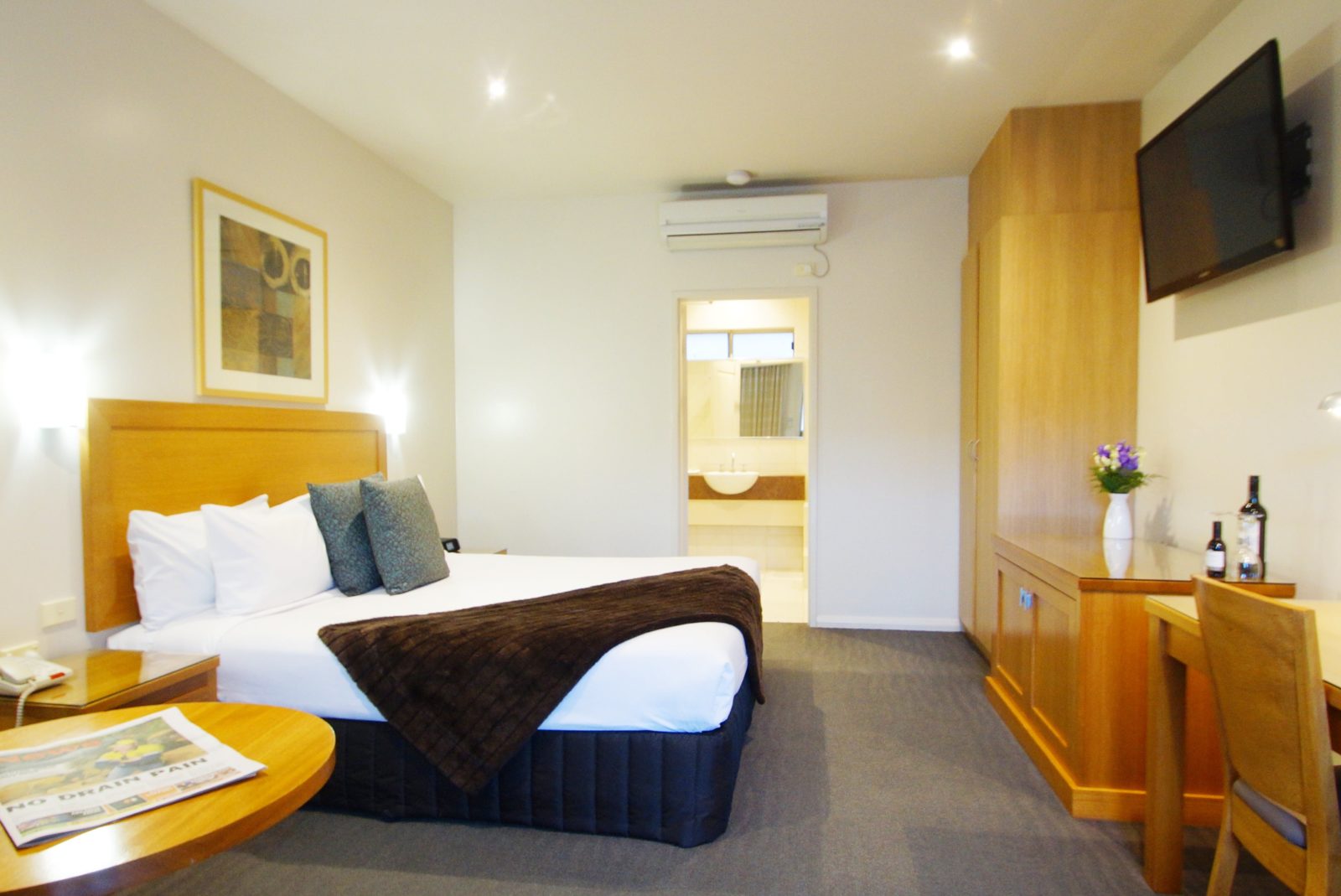 An intimate room featuring a king size bed an ensuite with a corner spa
