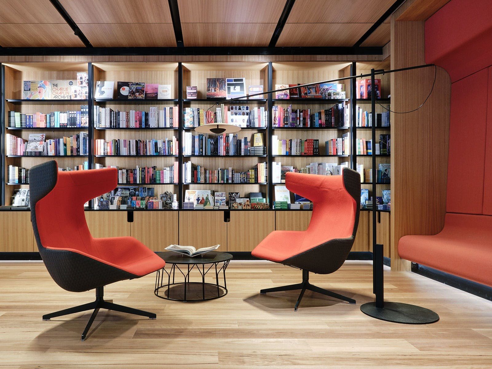 Two red chairs in front of a bookshelf