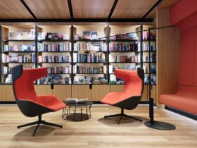 Two red chairs in front of a bookshelf
