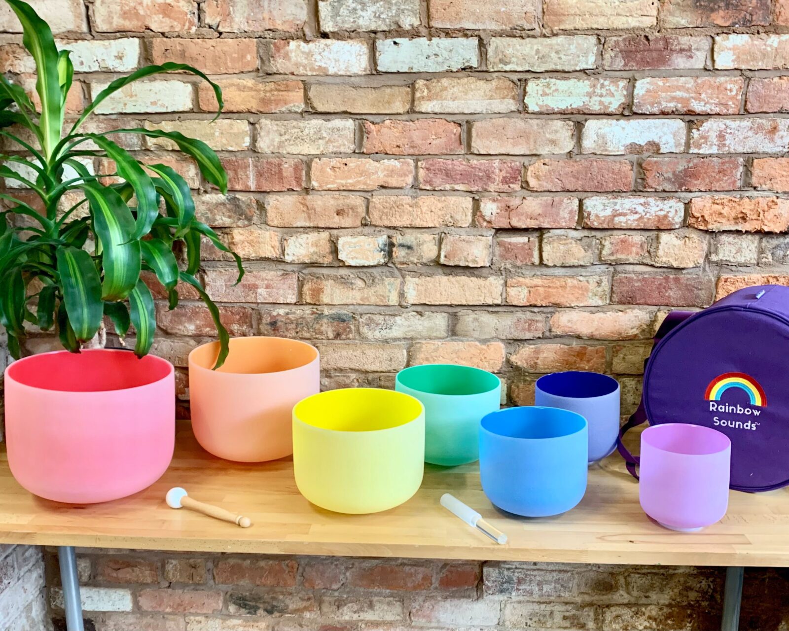 Seven coloured singing bowls on a table.